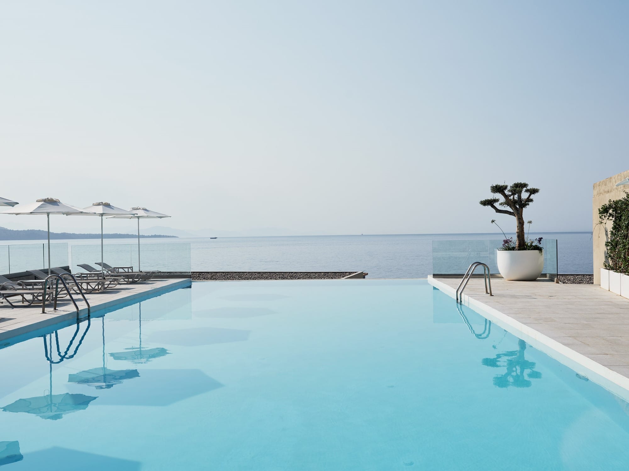 a pool with a deck and umbrellas by it