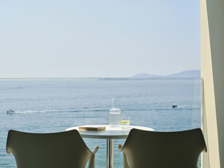 a table and chairs by a body of water