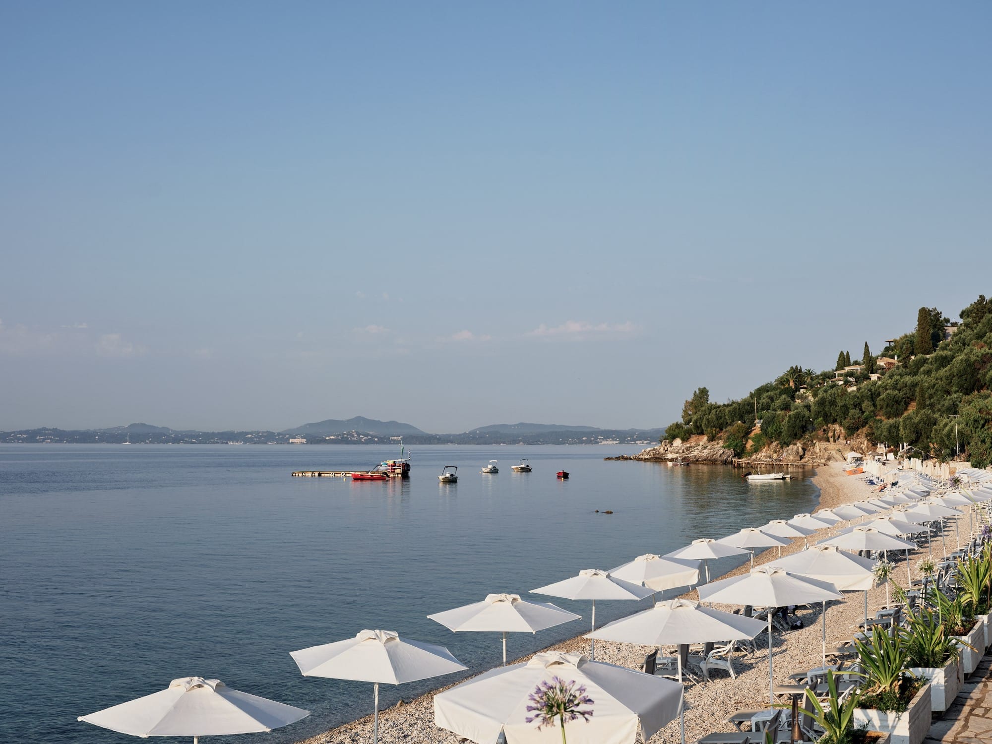 a beach with umbrellas and boats
