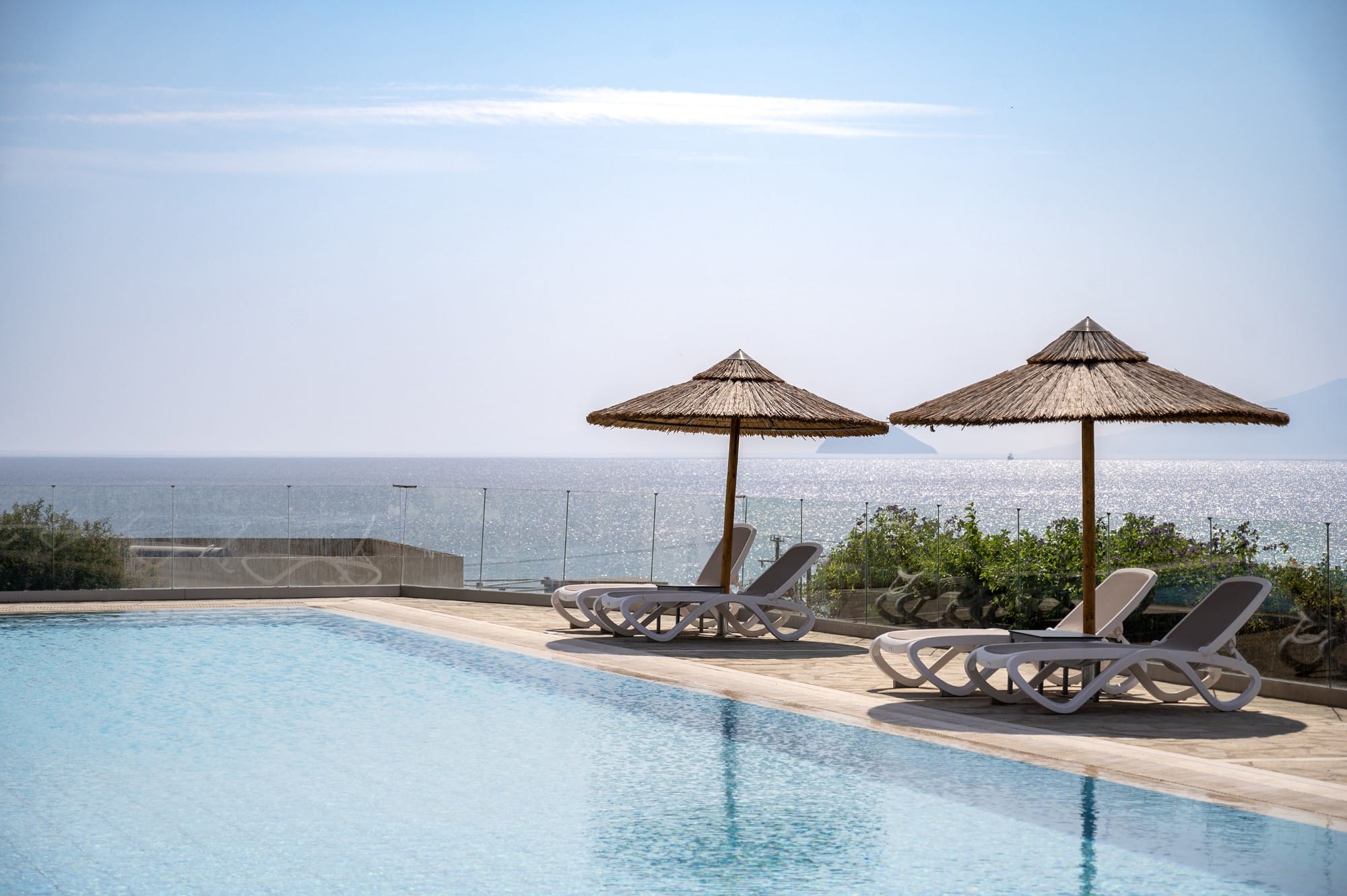 a pool with umbrellas and chairs by it
