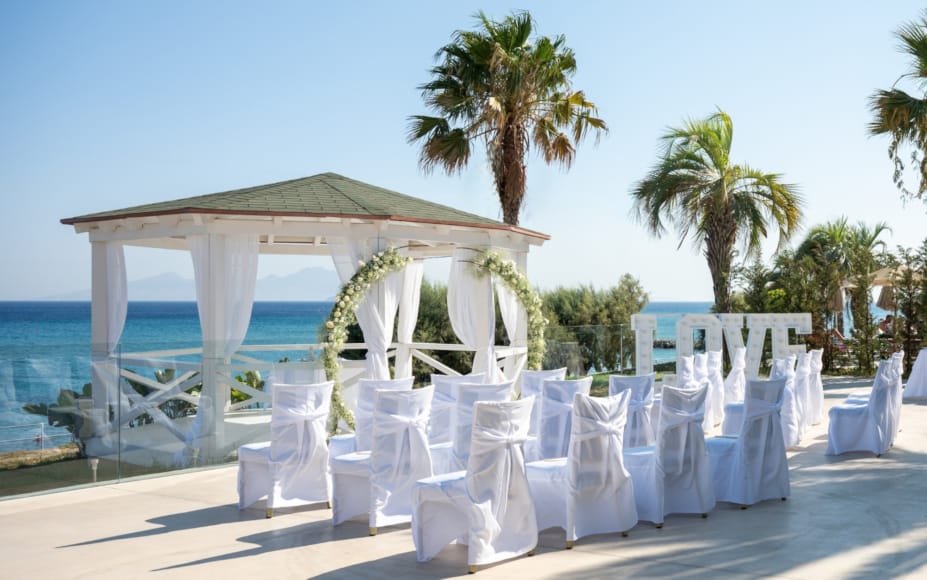 a row of white chairs on a beach