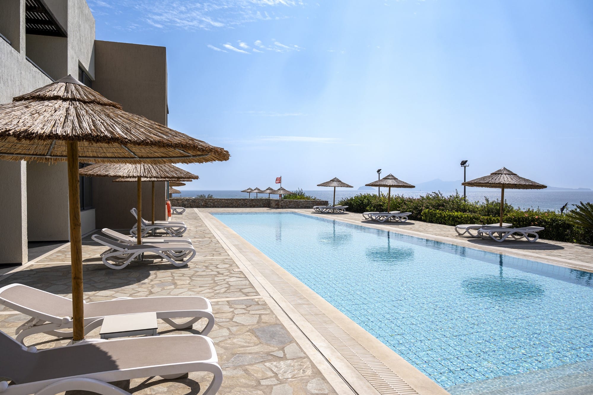 a pool with lounge chairs and umbrellas by it