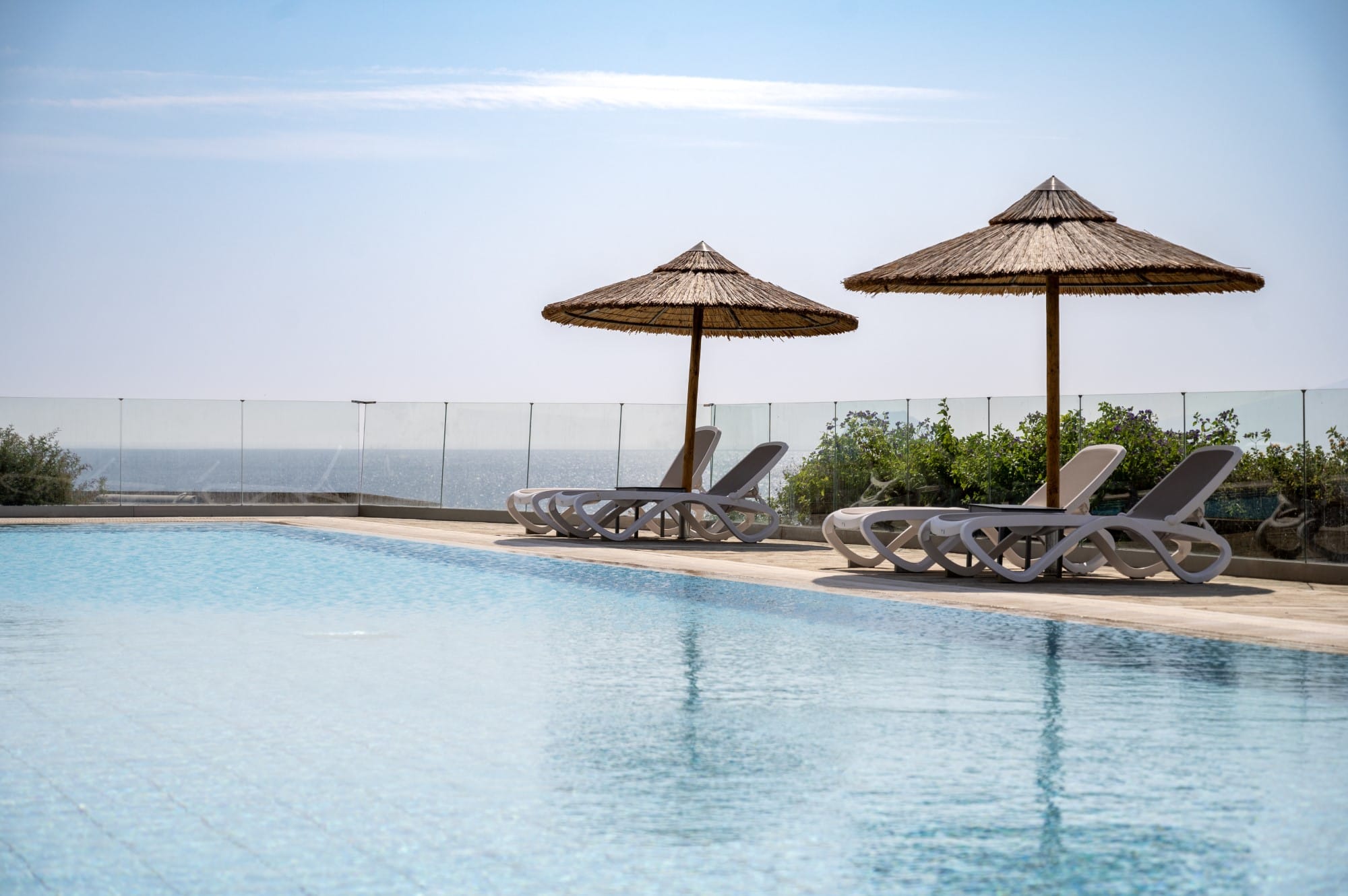 a pool with chairs and umbrellas by it