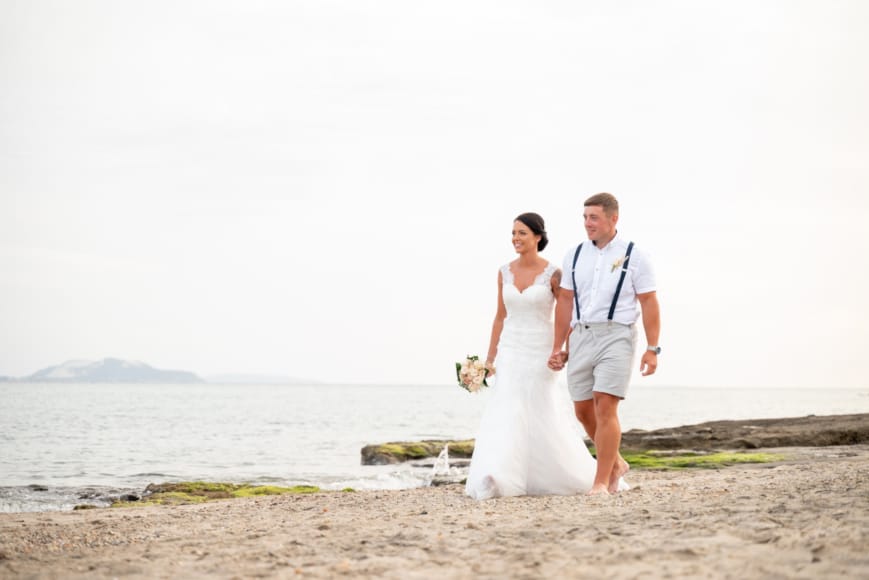 a man and woman walking on a beach