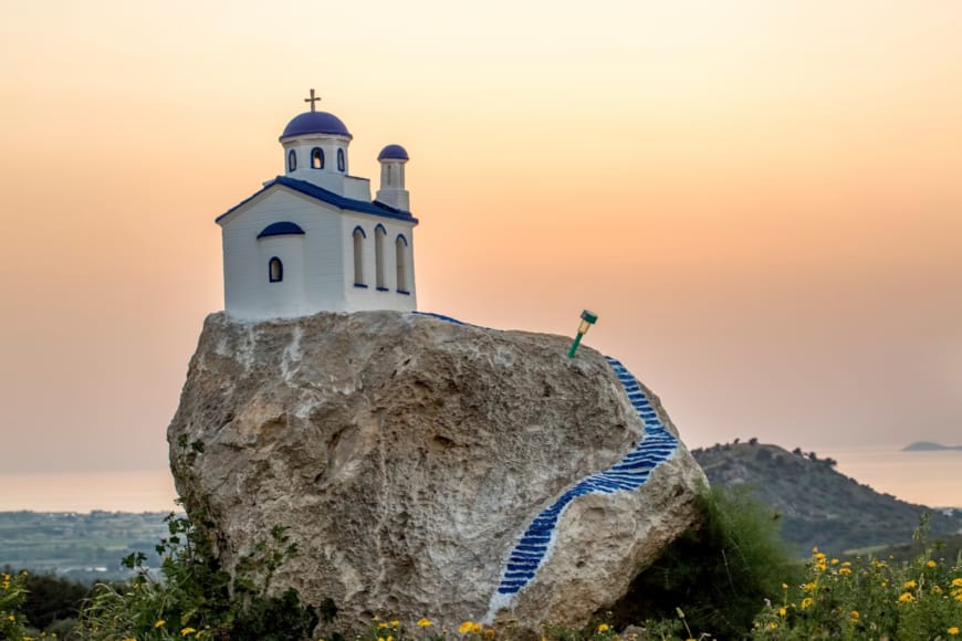 a white building on top of a rock