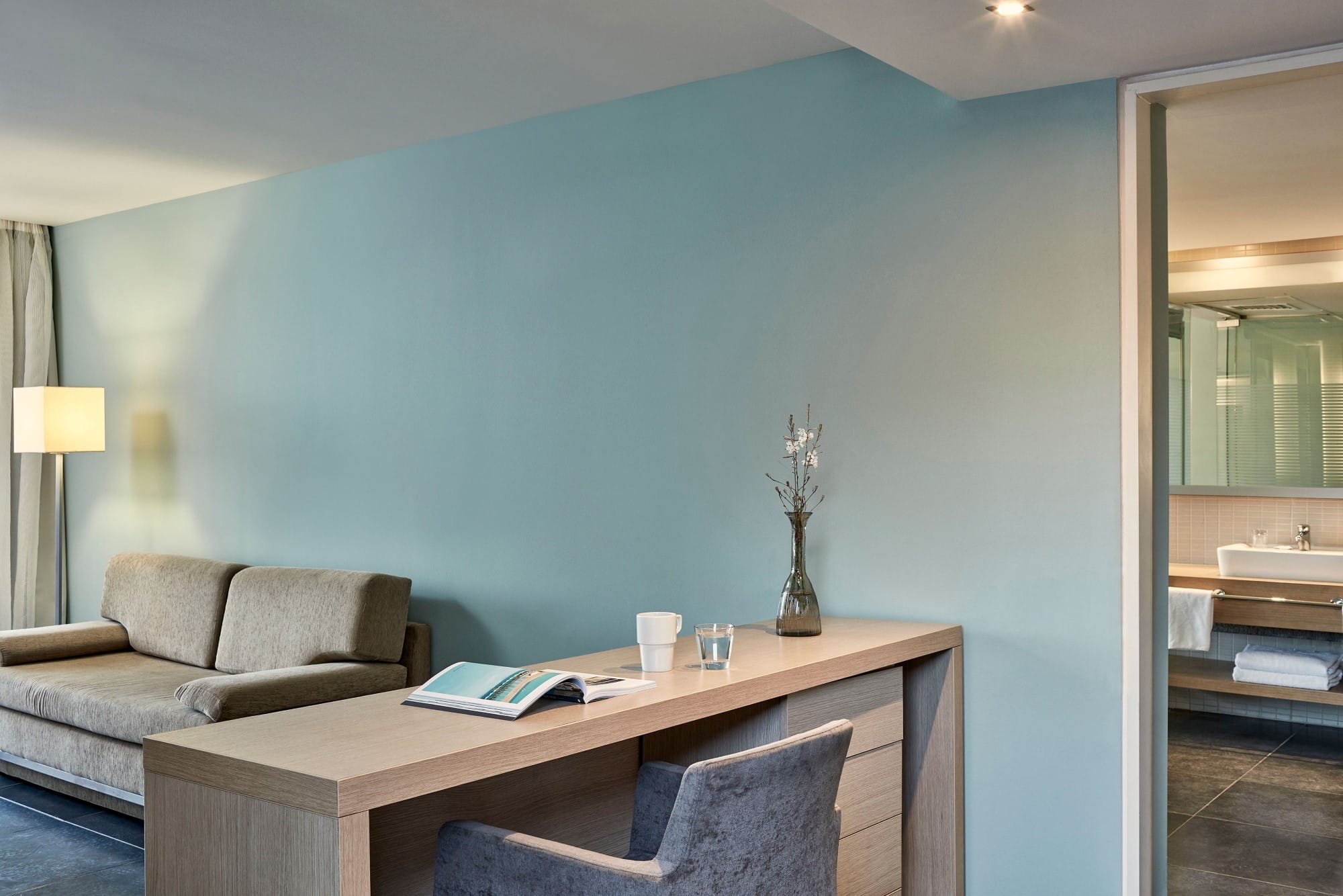 a living room with a desk and a couch