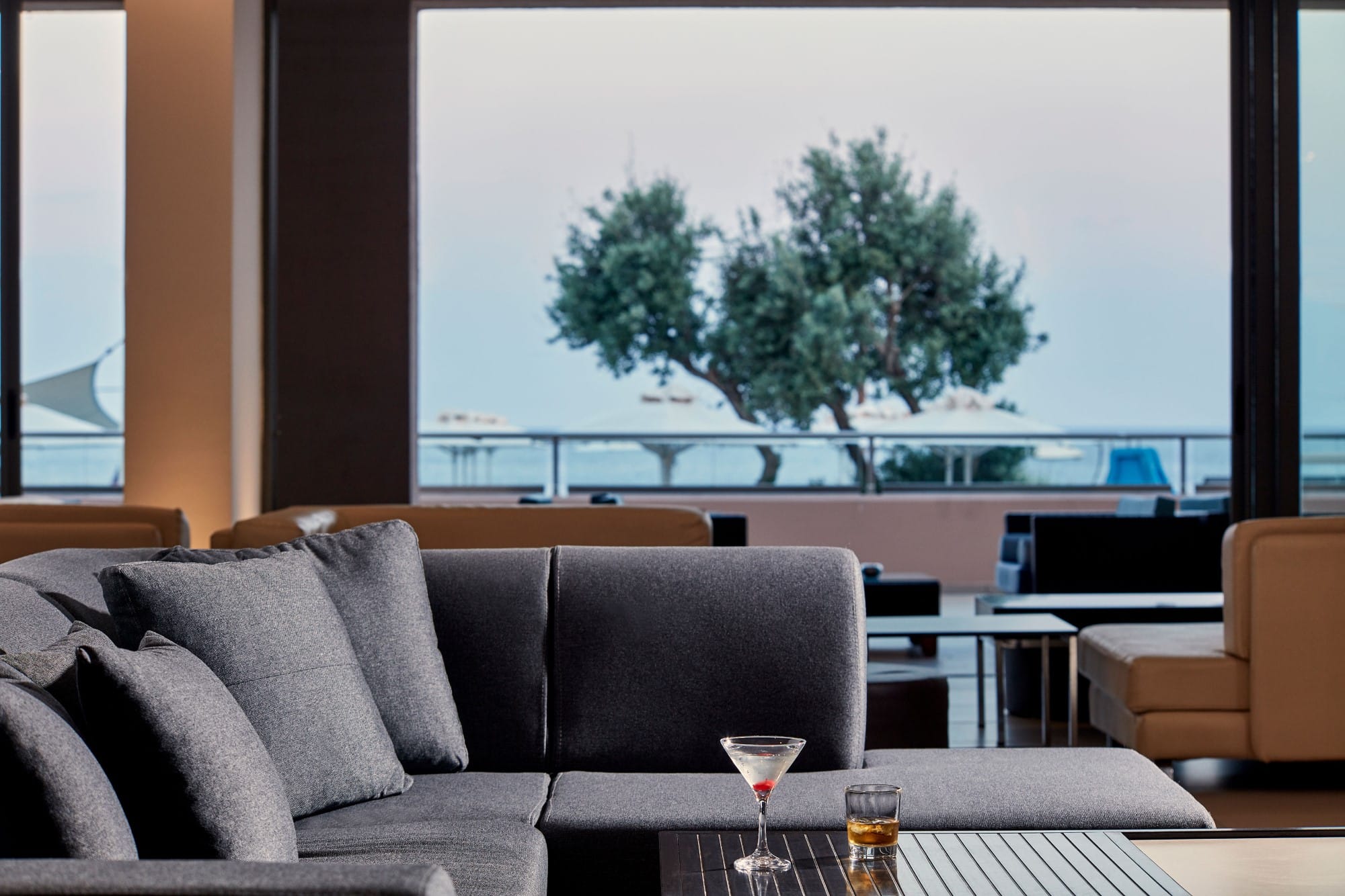 a couch with a table and a glass of wine on it