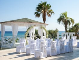 a row of white chairs on a beach