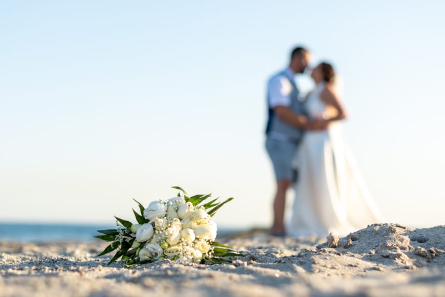 a man and woman holding hands on a beach