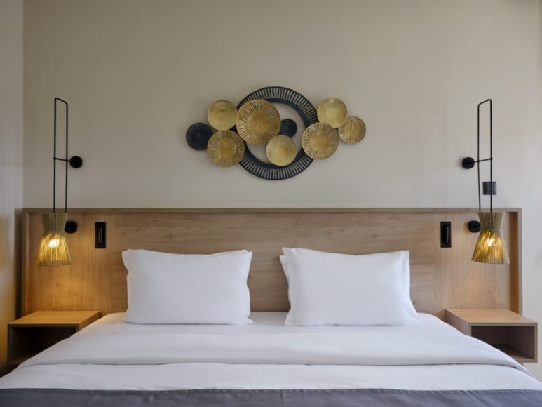 a bed with lamps on the wall