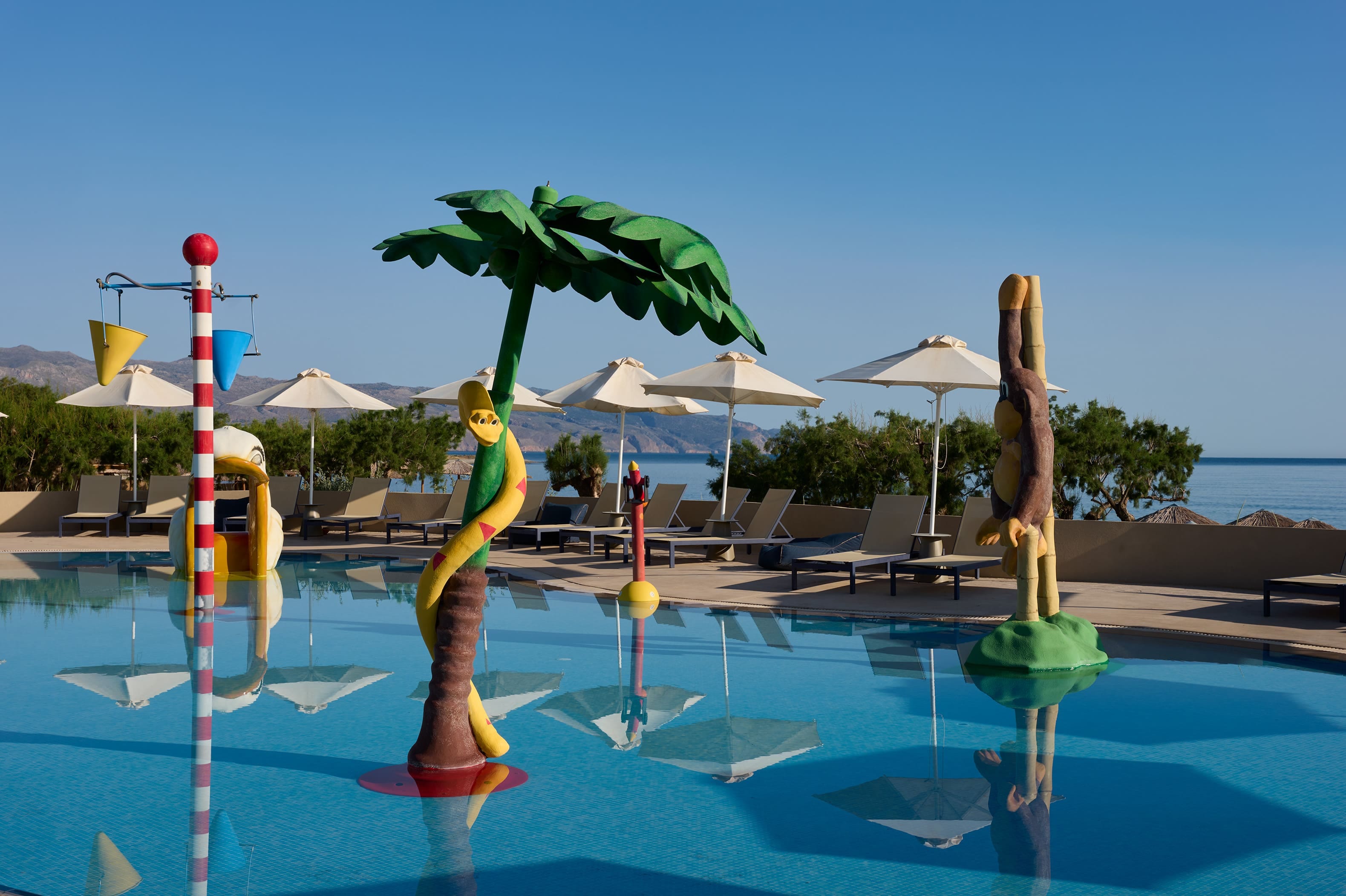 a person in a yellow garment in a pool with umbrellas