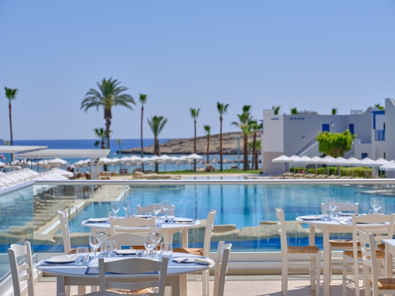 a pool with tables and chairs by it