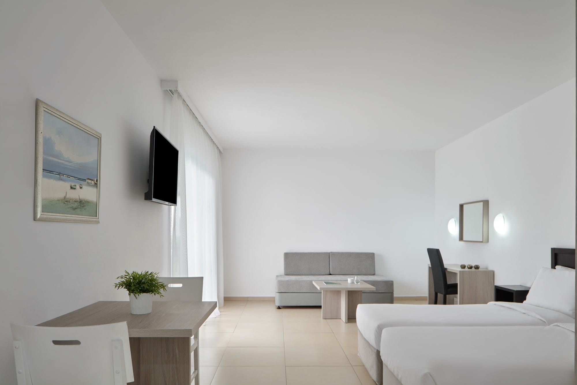 a room with white couches and a tv