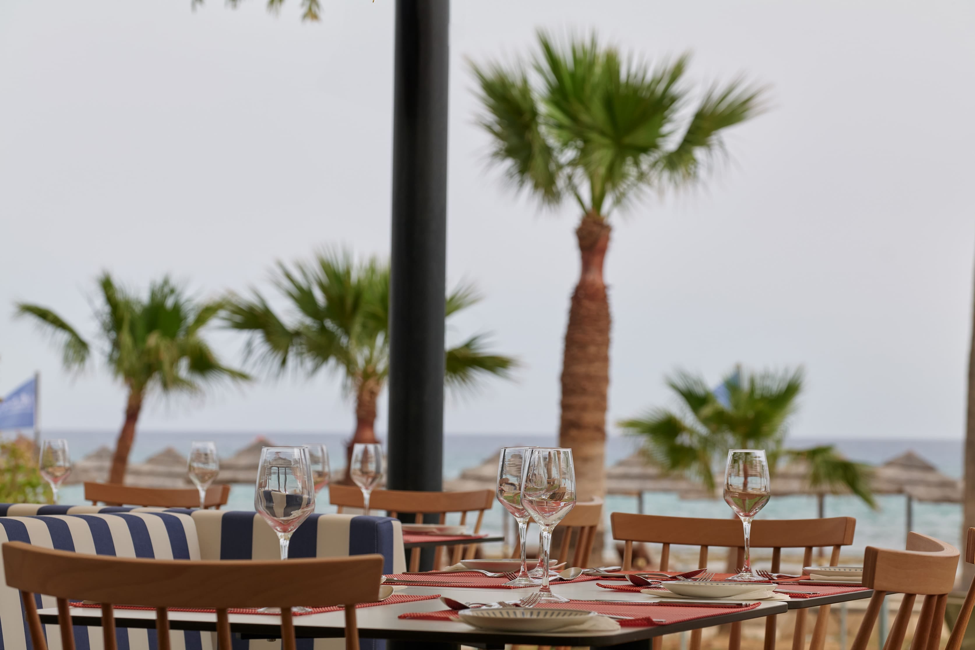 a table with glasses and plates on it by a beach
