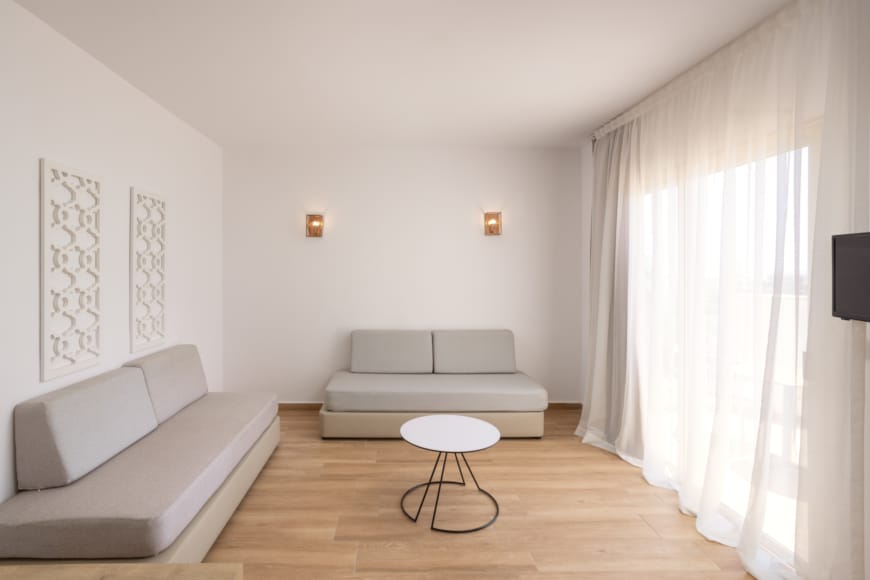 a room with white couches and a stool
