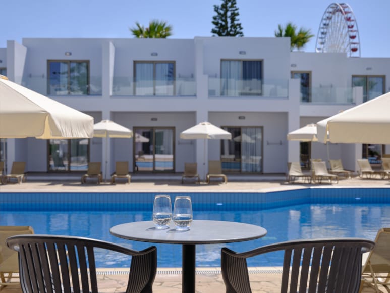 a pool with tables and chairs next to it