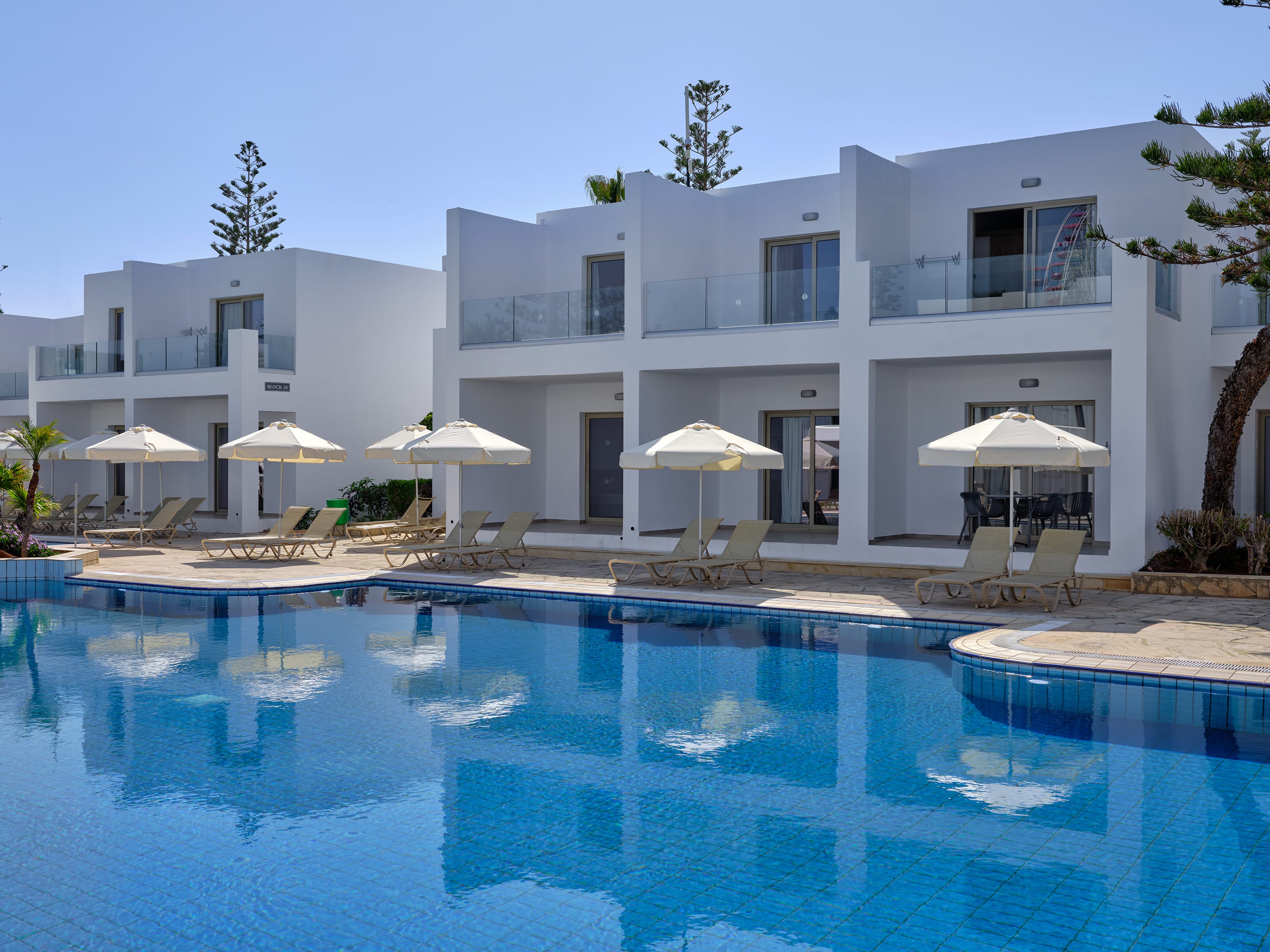 a pool with umbrellas by a house