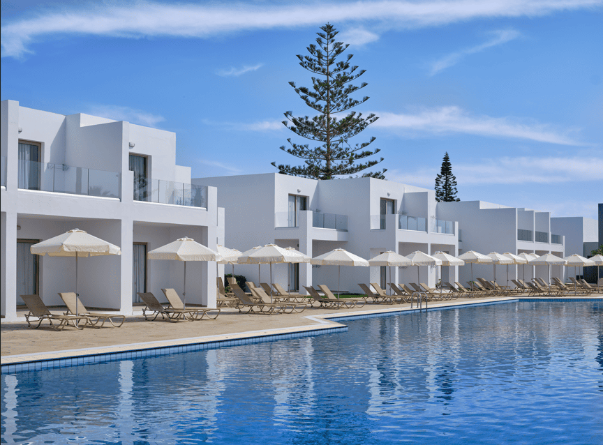 a pool with white buildings and trees