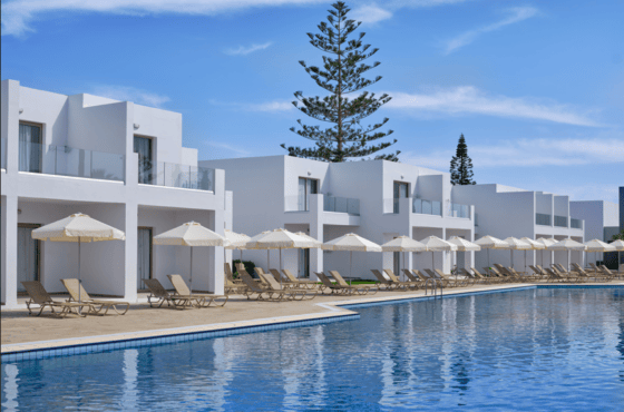 a pool with white buildings and trees