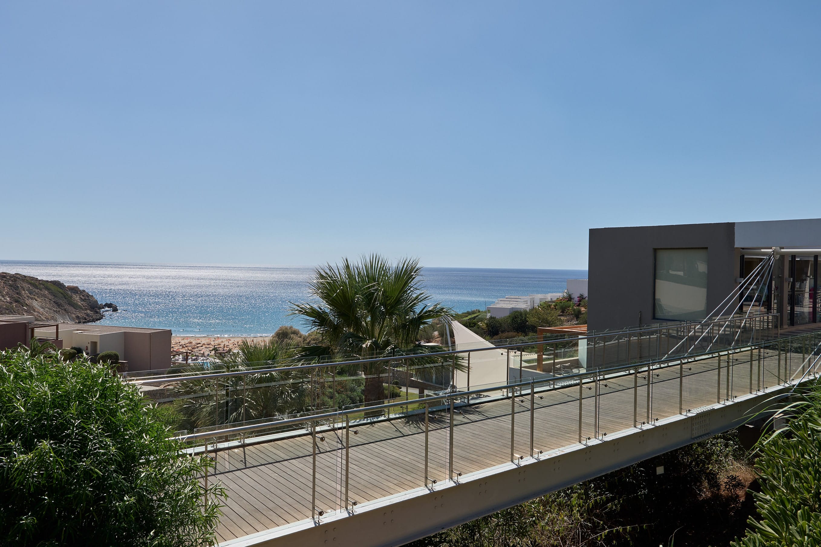 a building with a fence and trees by the ocean