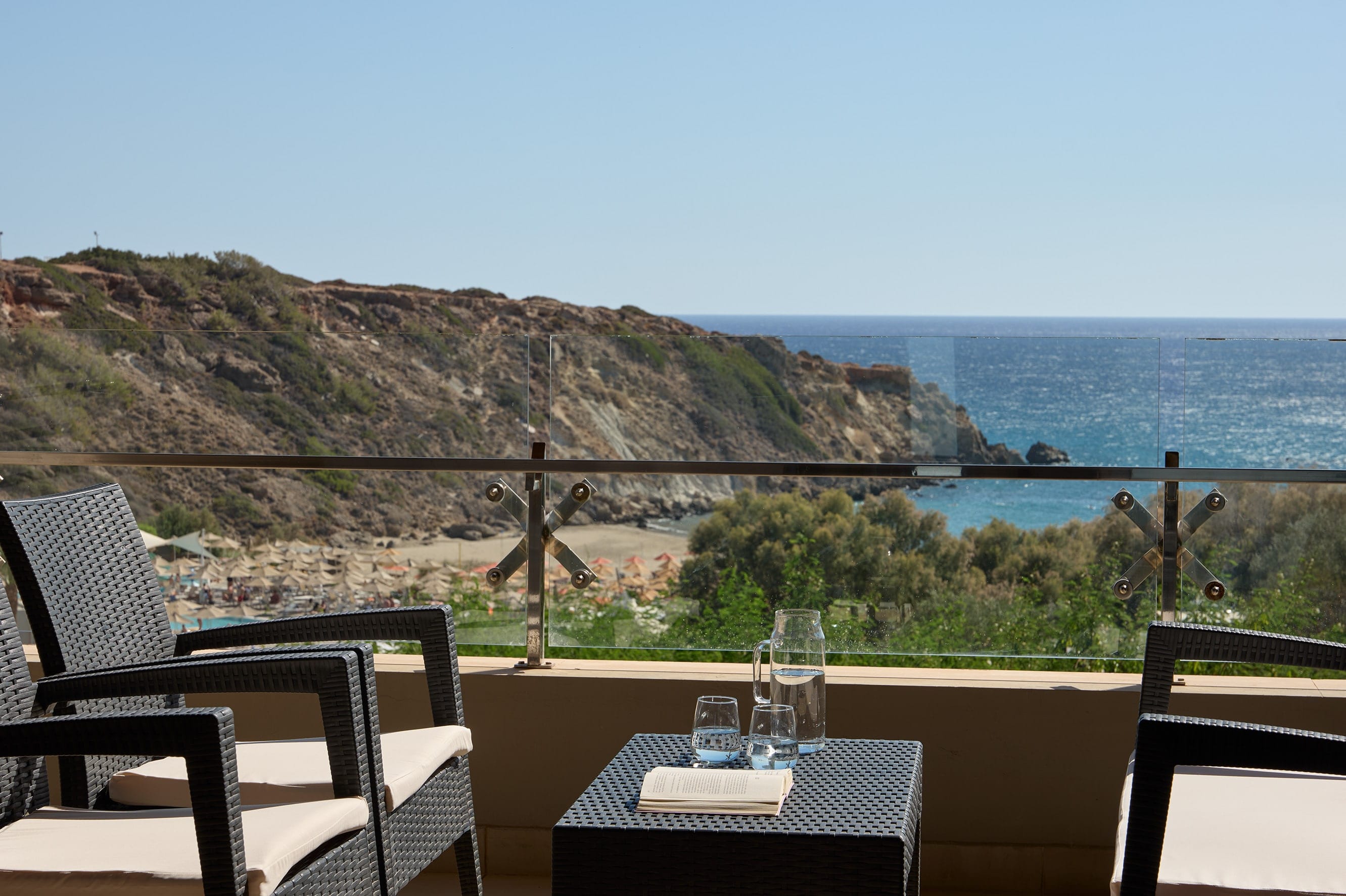 a table and chairs on a balcony overlooking a body of water