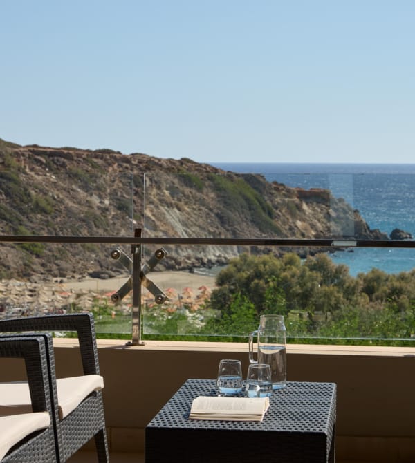 a table and chairs on a balcony overlooking a body of water