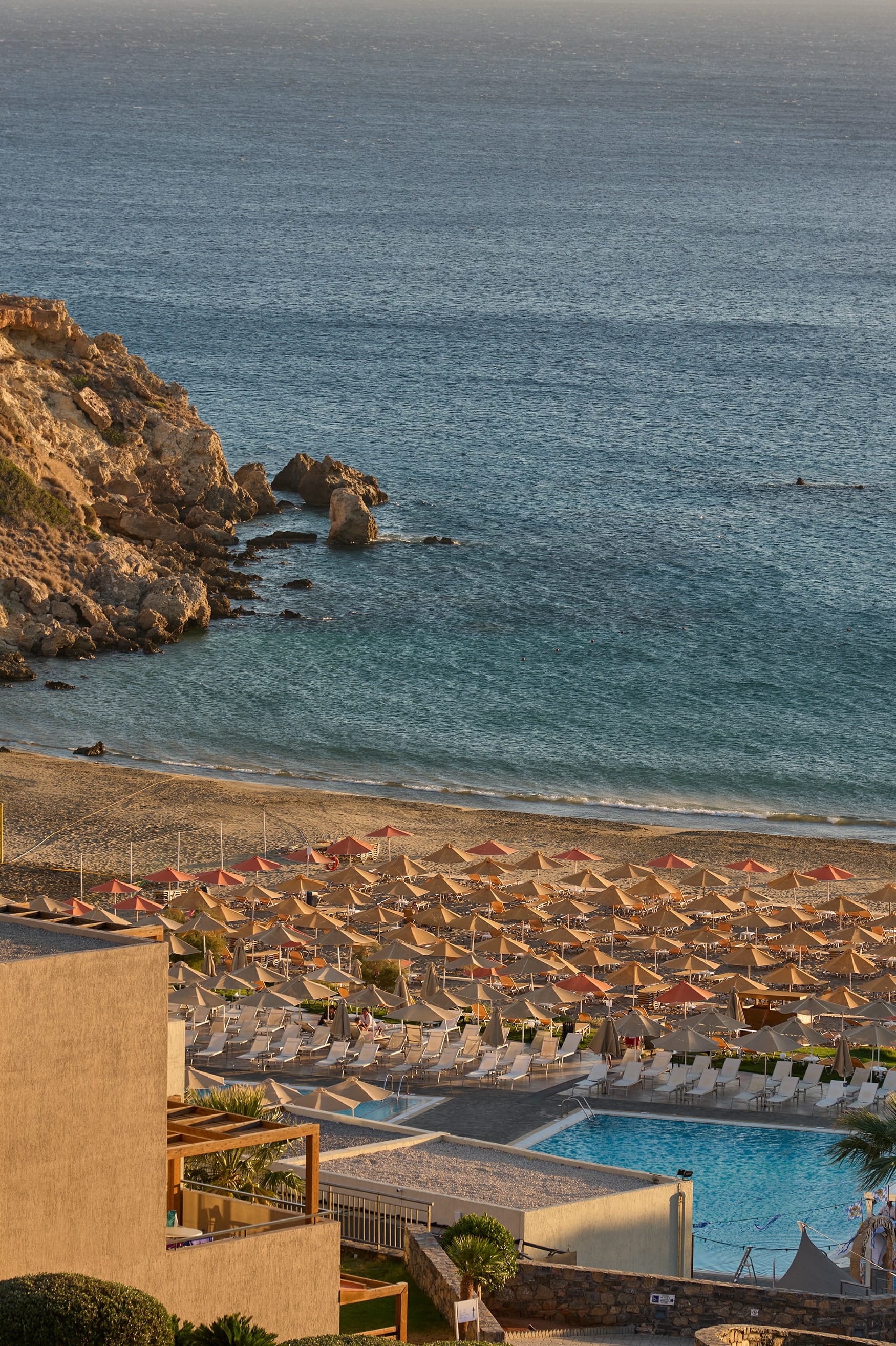 a beach with a pool and rocks