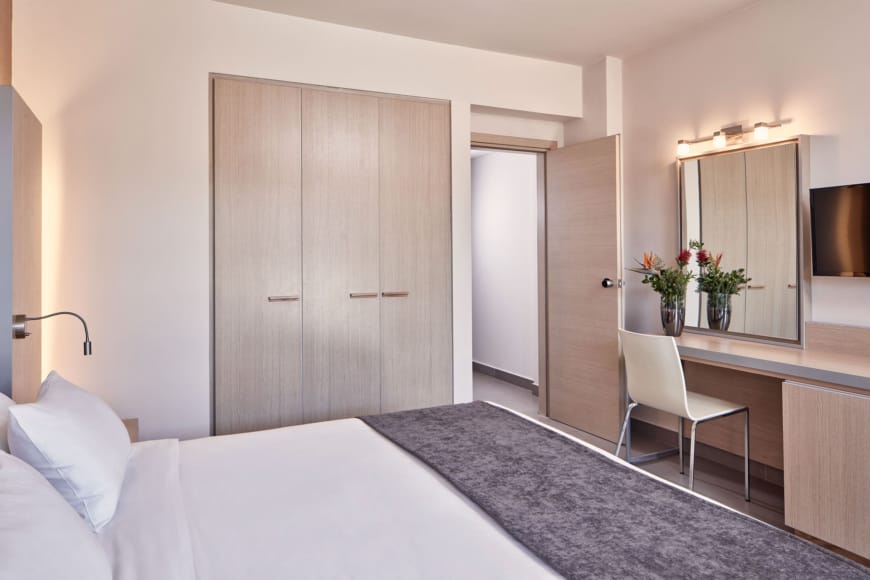 a bed and a chair in a room with white walls