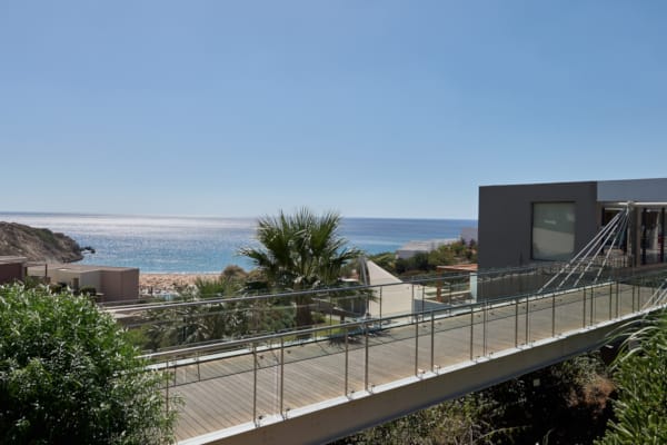 a building with a fence and trees by the ocean