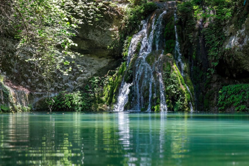 a waterfall over a body of water