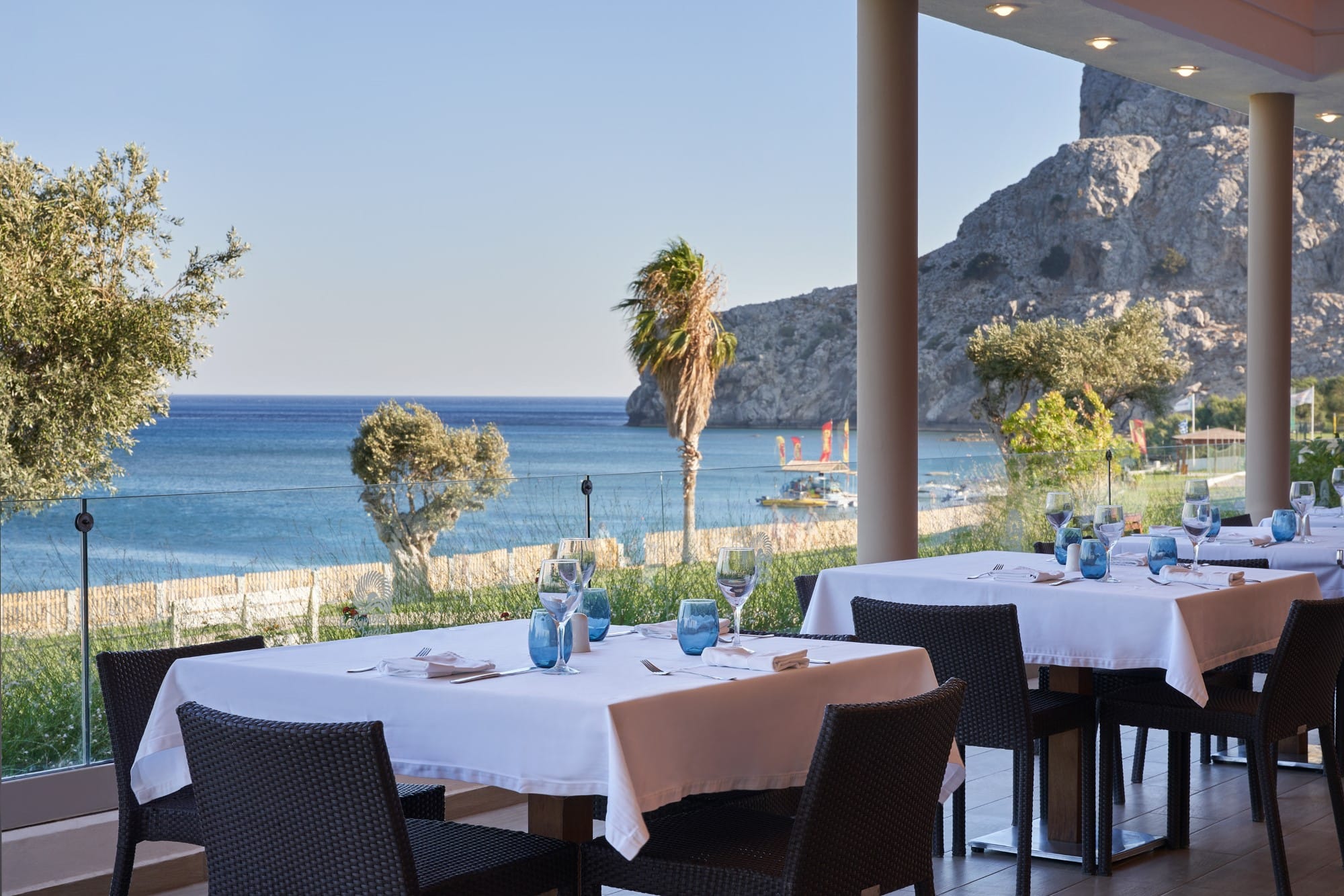 a set of tables and chairs next to a body of water