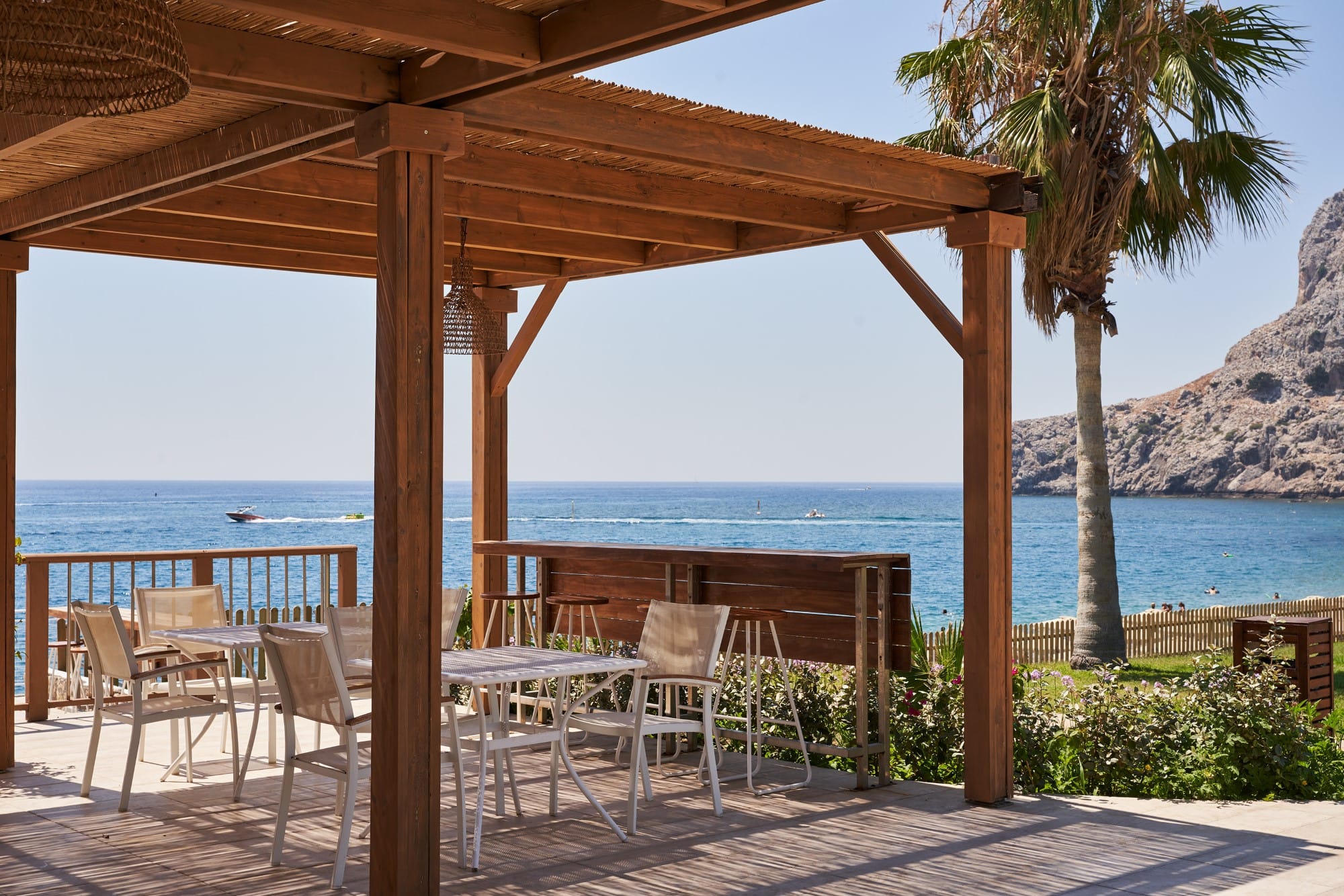a deck with chairs and tables by the water