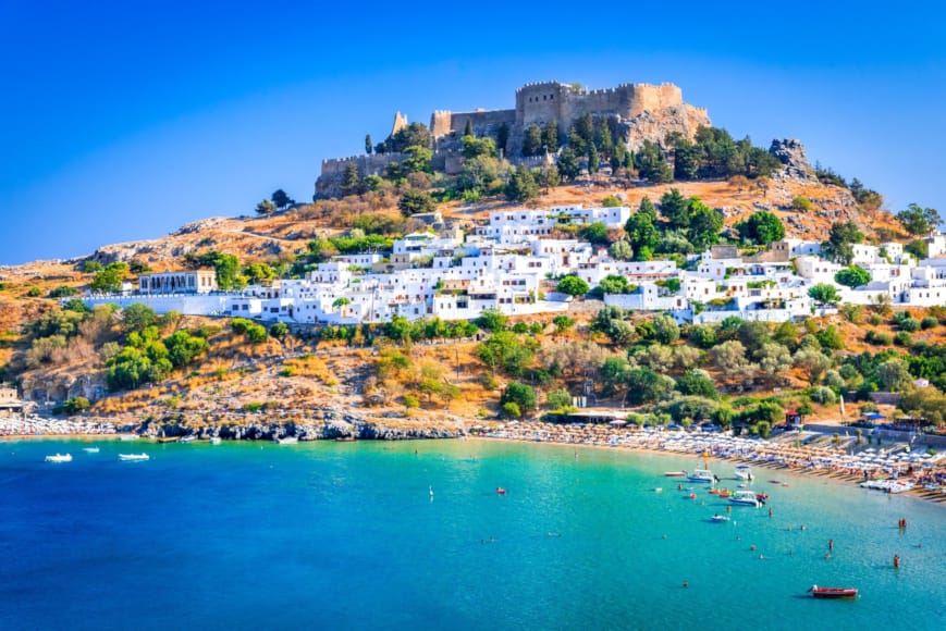 a beach with a hill and buildings