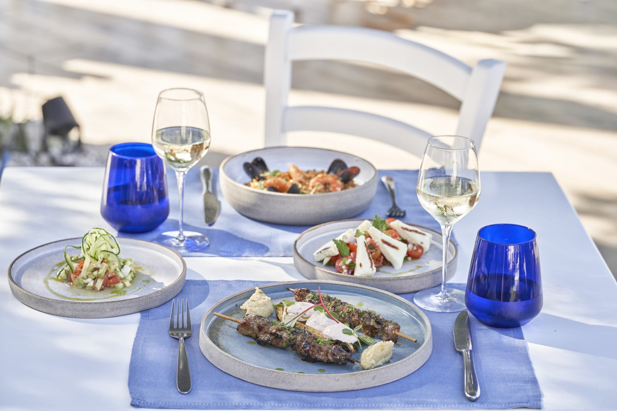 a table with plates of food and glasses of wine