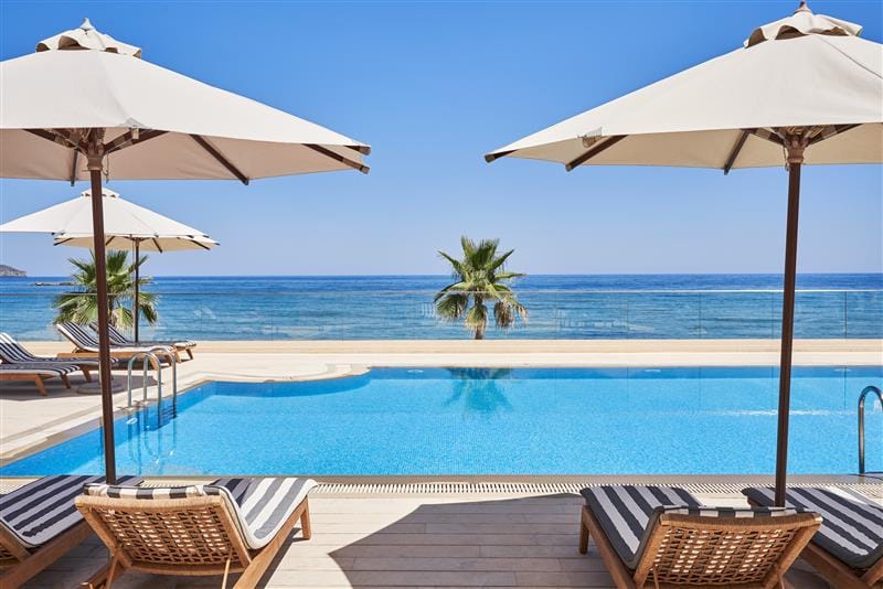 a pool with chairs and umbrellas by it