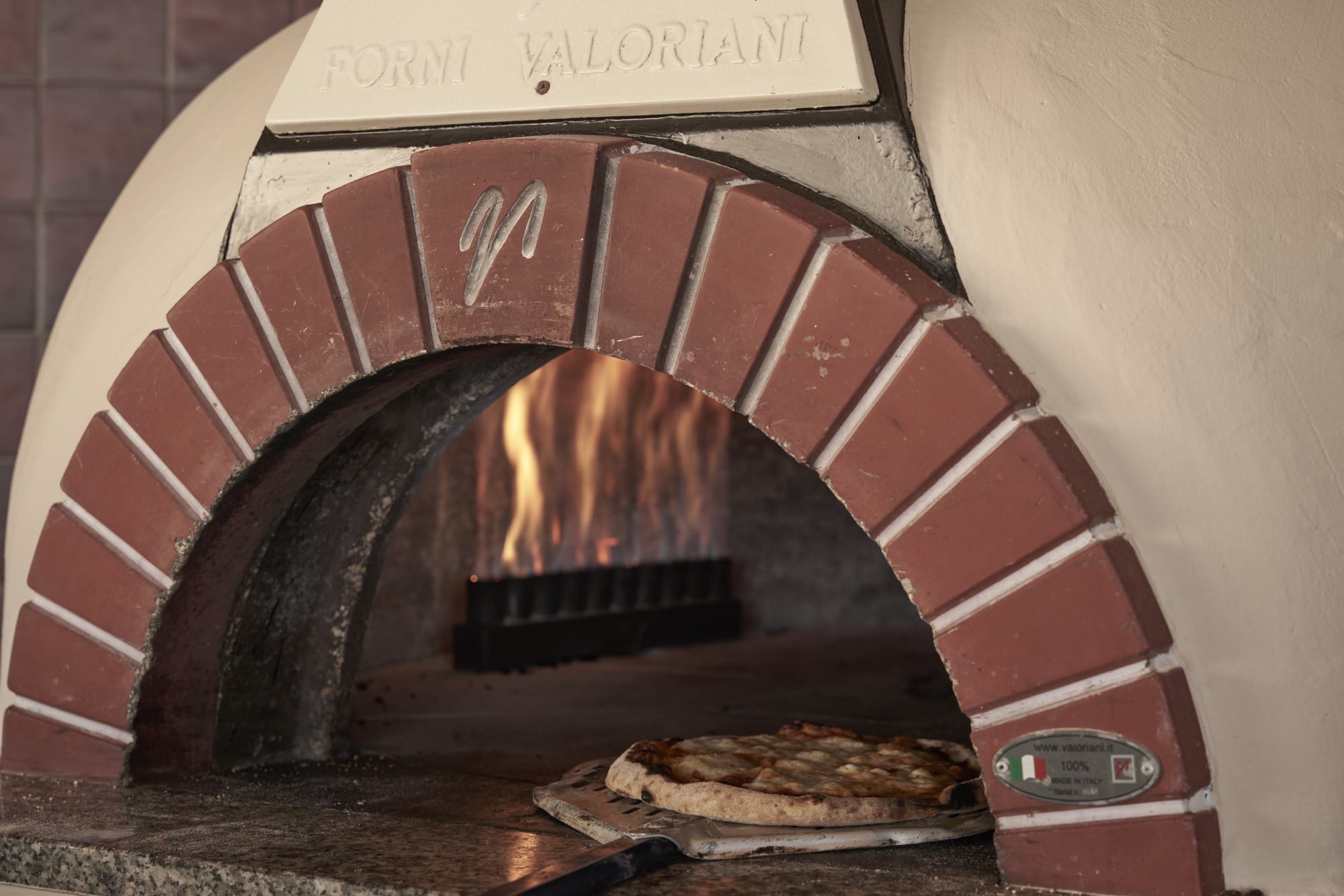 a brick oven with a pizza in it