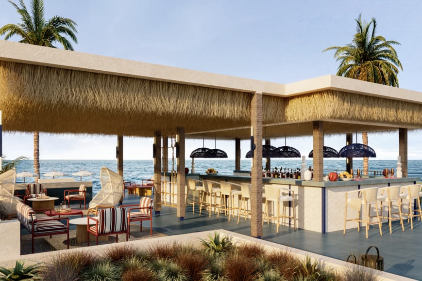 a patio with chairs and umbrellas by a beach