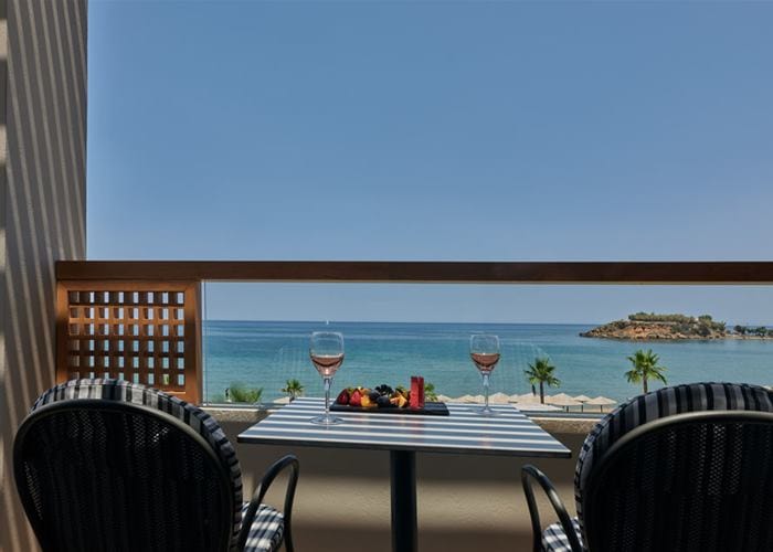 a table with wine glasses on it by a body of water