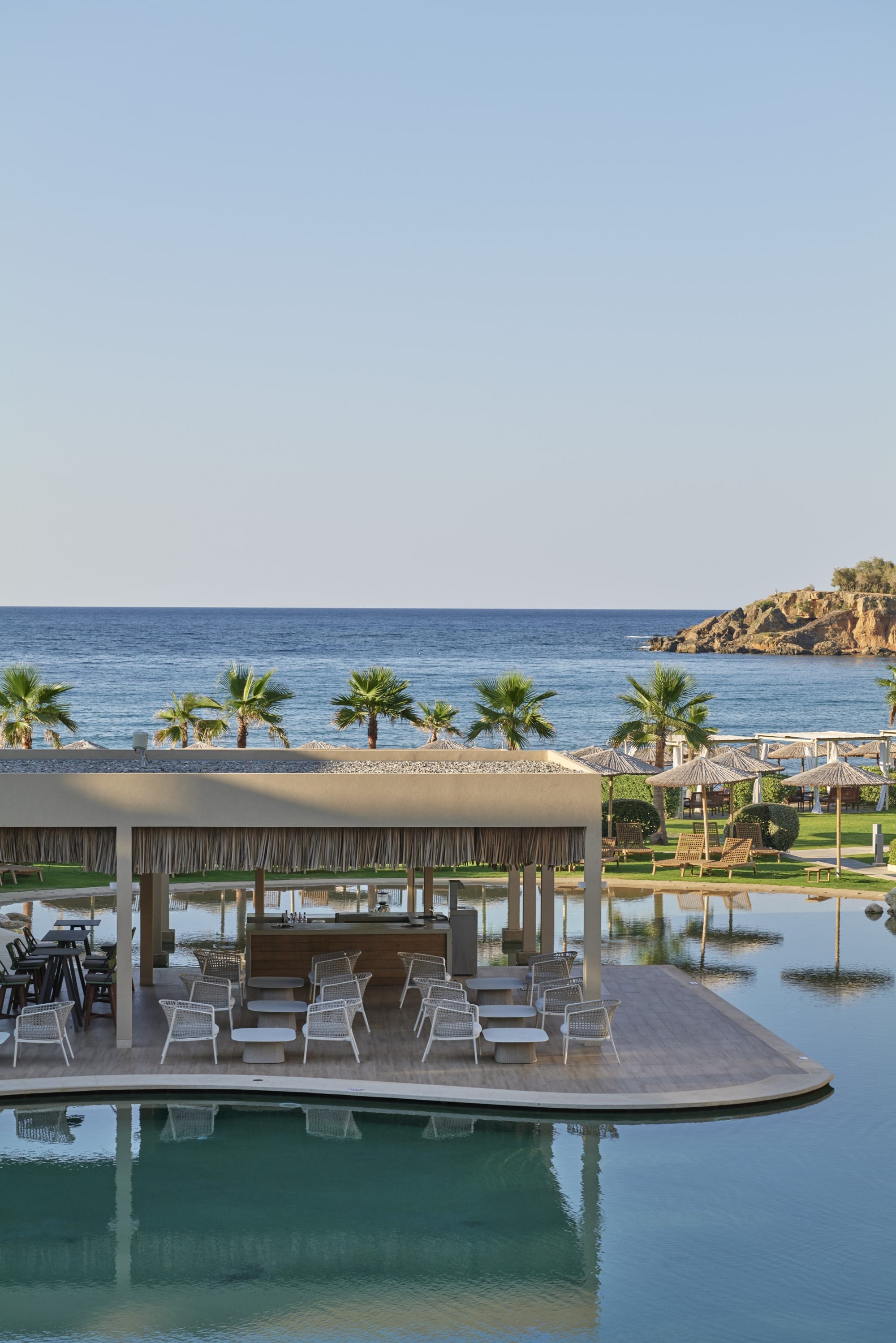 a deck with chairs and umbrellas by a body of water