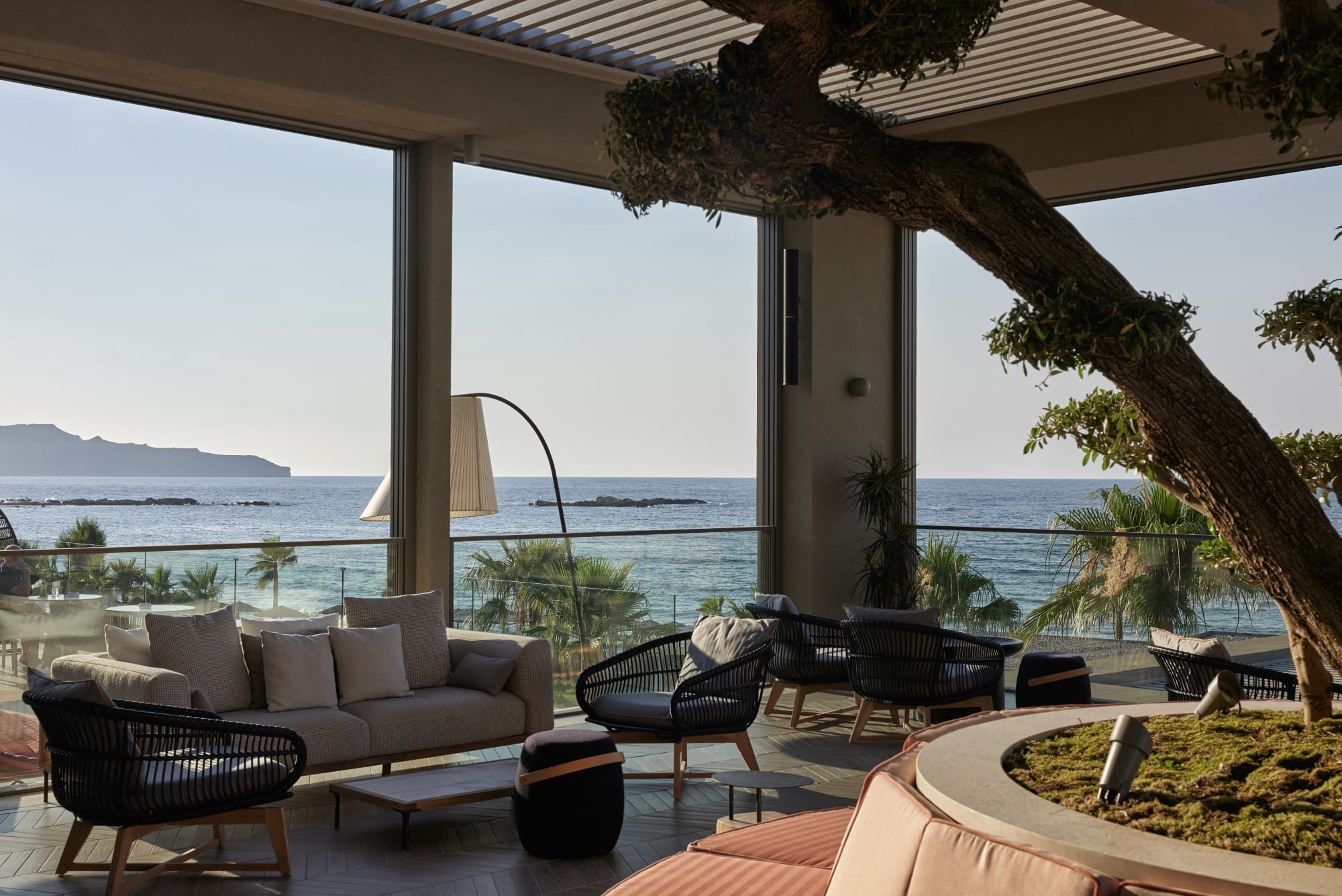 a patio with chairs and a table with a view of the ocean