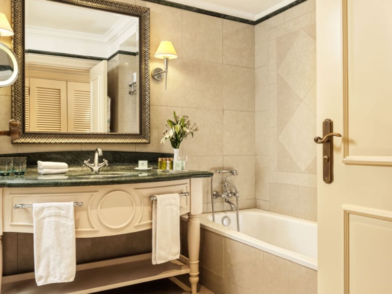 a bathroom with a tub sink and mirror