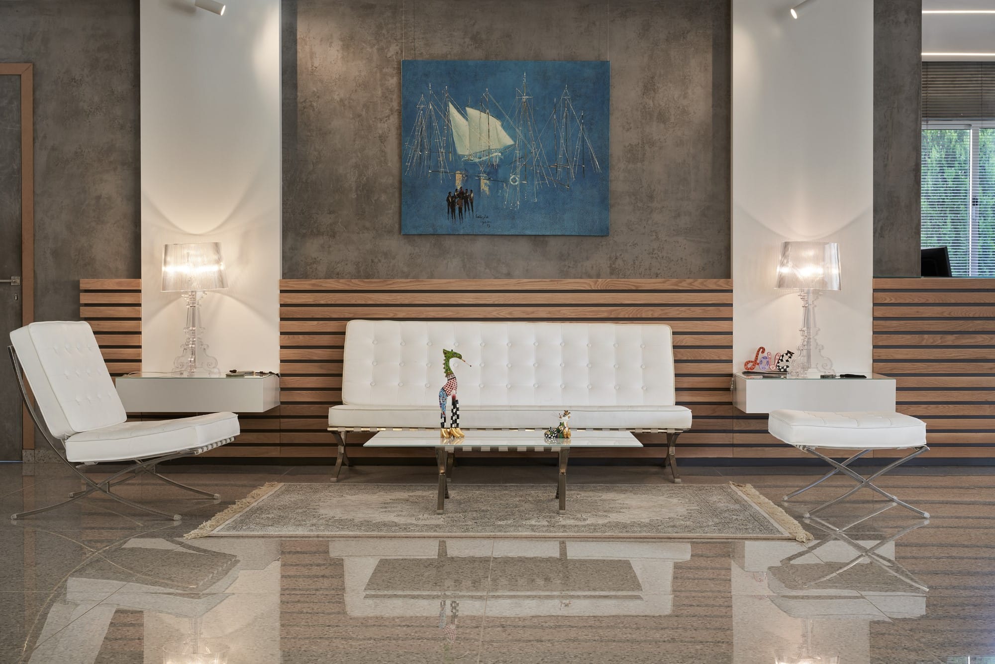 a room with white couches and a painting on the wall