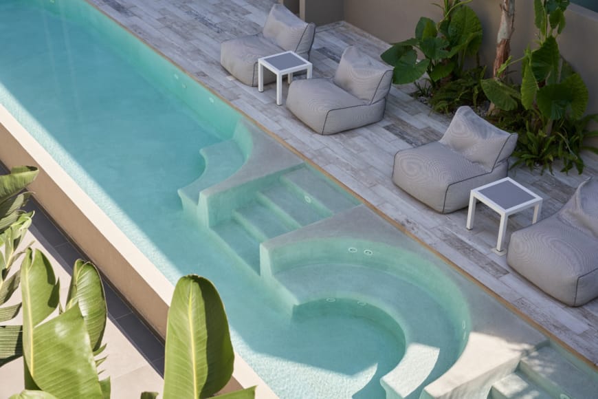 a pool with white chairs