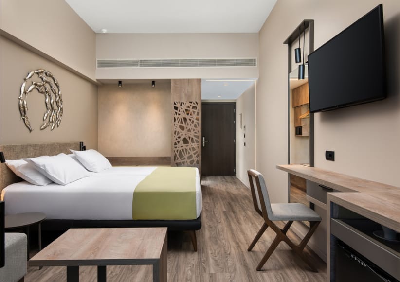a bedroom with a bed desk and tv