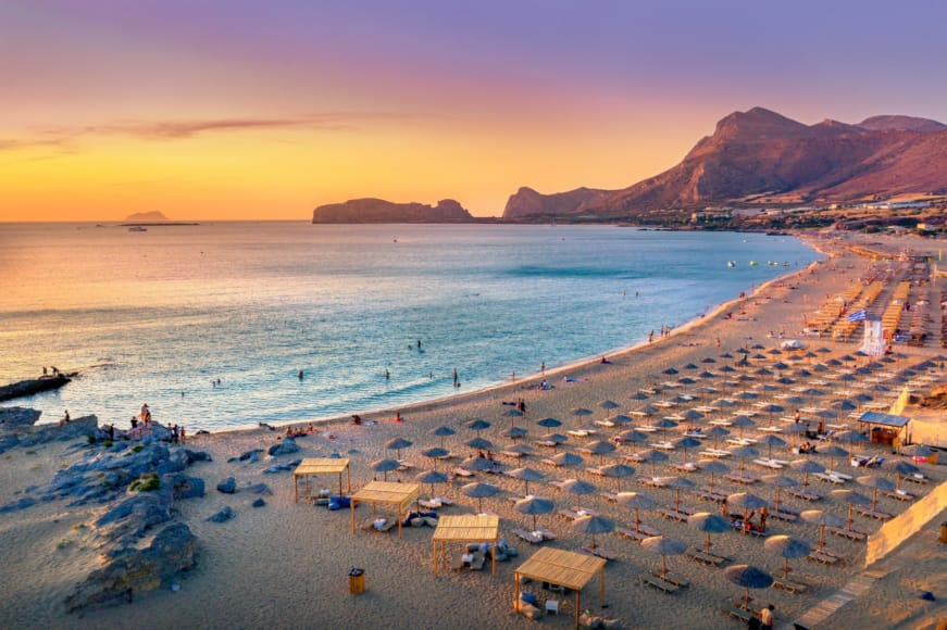 a beach with many people and buildings