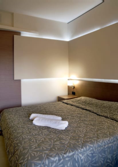 a hotel room with a bed and a lamp