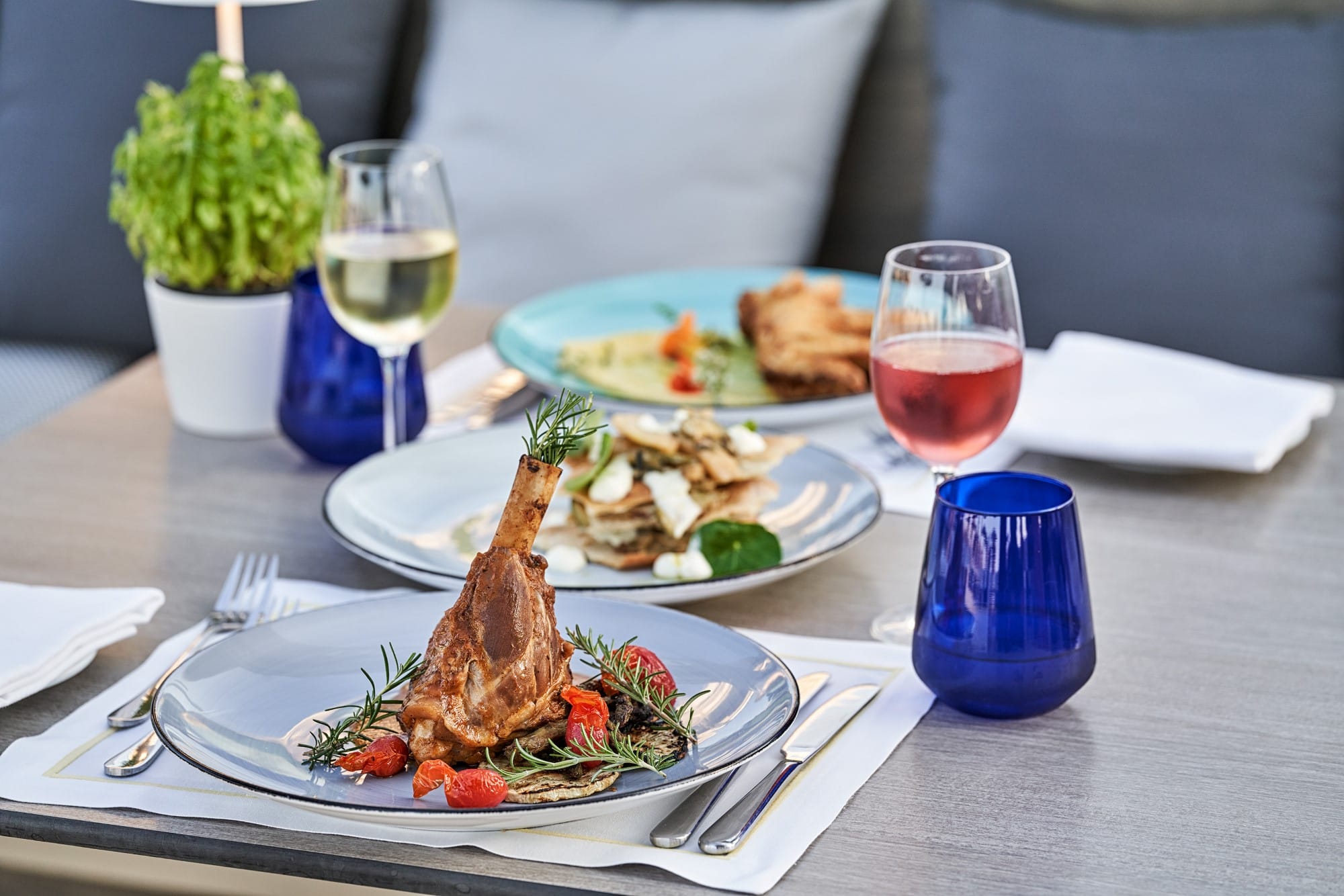 a table with plates of food and glasses of wine
