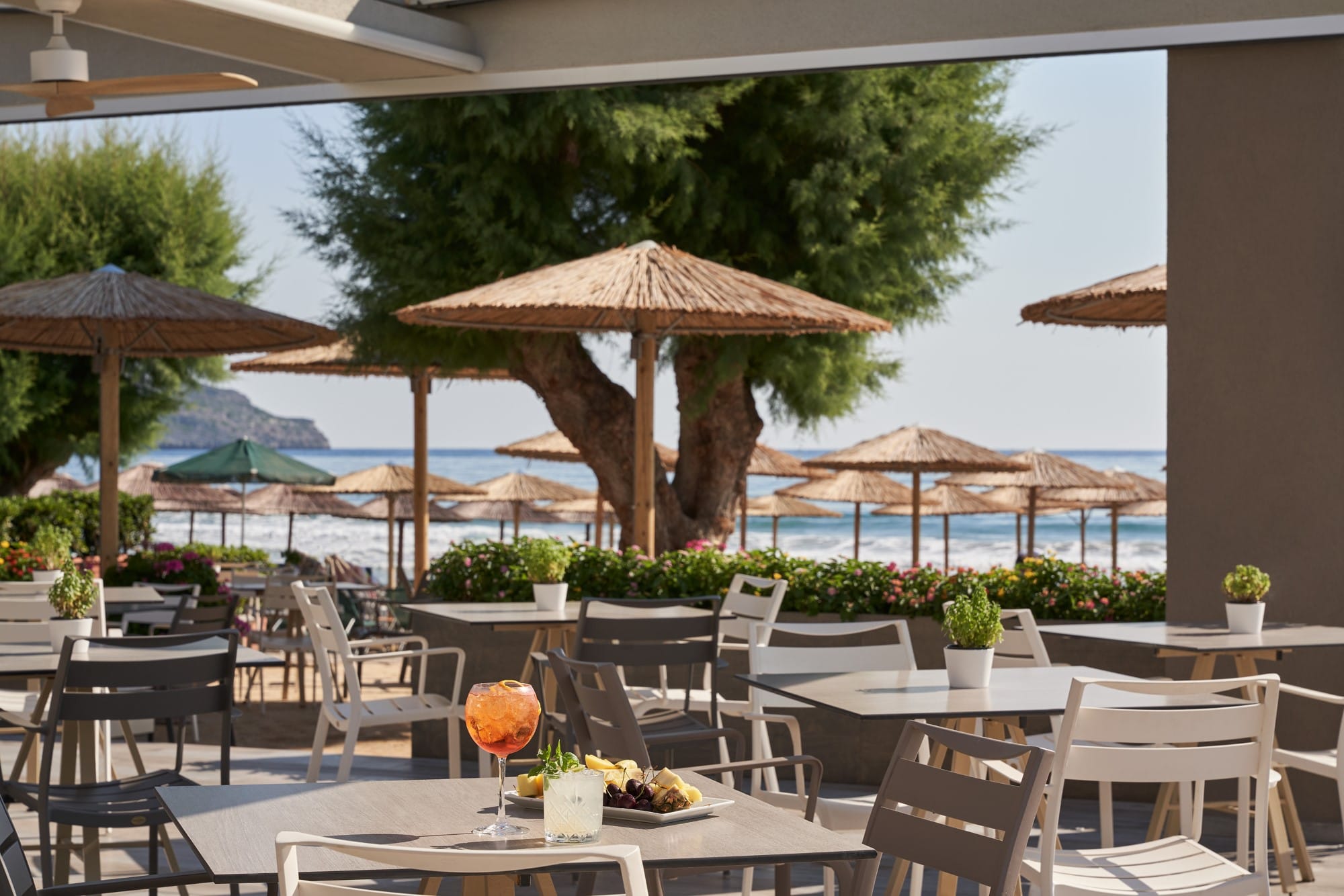 a group of tables and chairs next to a body of water