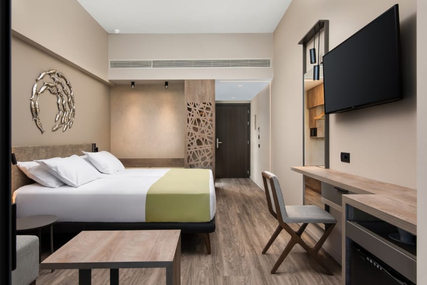 a room with a bed desk and a tv