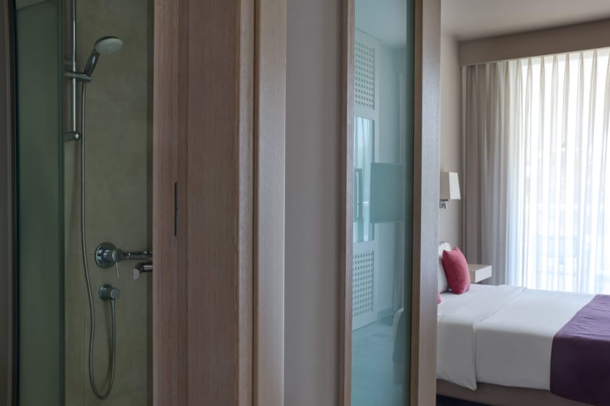 a bathroom with a bed and a shower unit